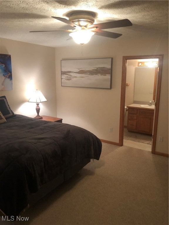 bedroom with light carpet, ensuite bath, a textured ceiling, ceiling fan, and sink