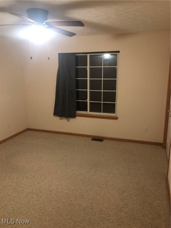 spare room featuring carpet and a textured ceiling