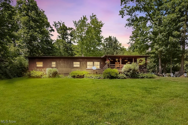 back house at dusk featuring a yard