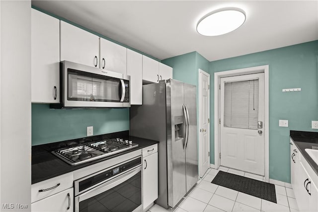 kitchen featuring white cabinets, appliances with stainless steel finishes, and light tile patterned floors