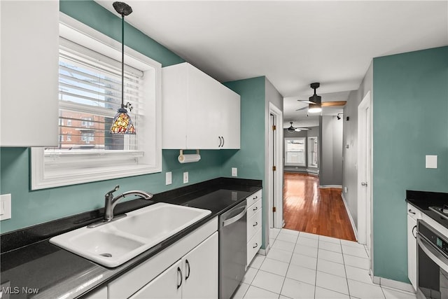 kitchen with white cabinetry, sink, decorative light fixtures, light tile patterned floors, and appliances with stainless steel finishes