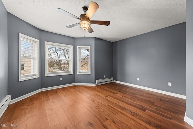 unfurnished room with hardwood / wood-style floors, baseboard heating, and a textured ceiling