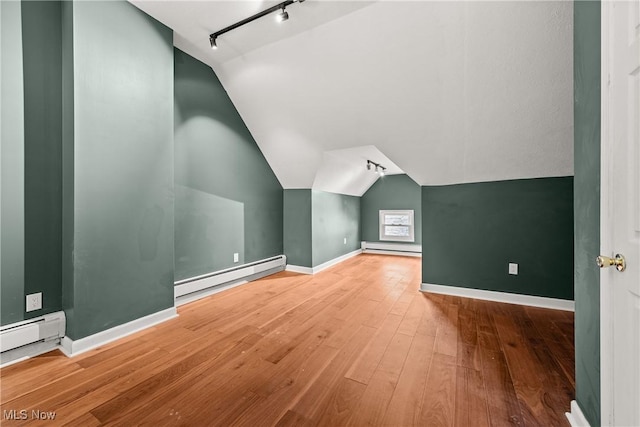 bonus room featuring hardwood / wood-style flooring, lofted ceiling, and a baseboard heating unit