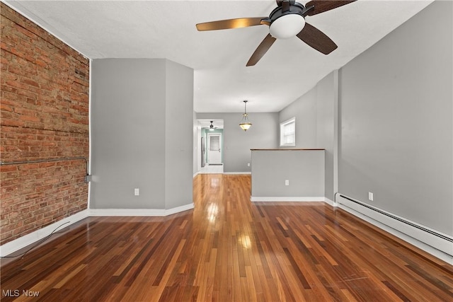 unfurnished living room with ceiling fan, hardwood / wood-style floors, brick wall, and a baseboard heating unit