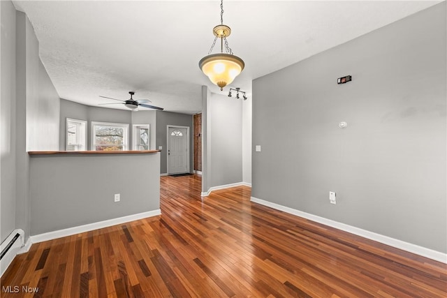 unfurnished room with ceiling fan, wood-type flooring, a textured ceiling, and a baseboard radiator