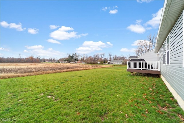 view of yard with a rural view and a deck