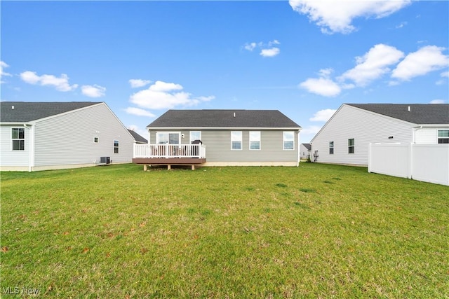 back of property with a deck, central AC unit, and a lawn