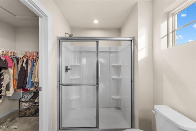 bathroom with toilet and an enclosed shower