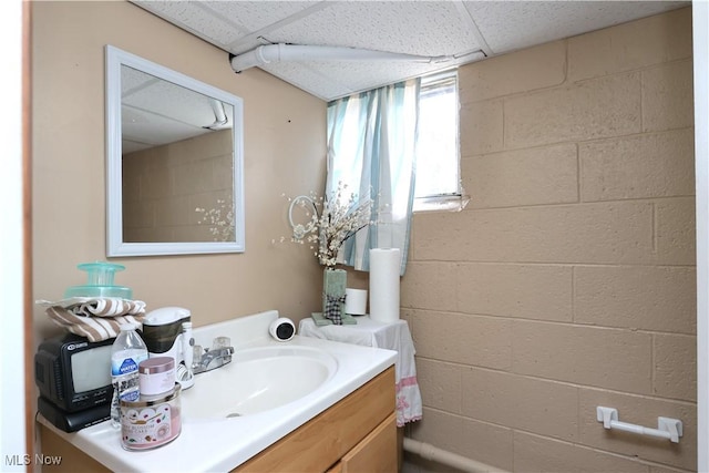 bathroom with a paneled ceiling and vanity