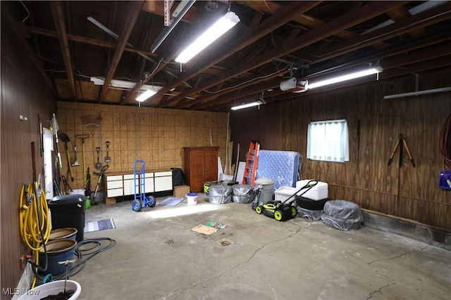 garage featuring a garage door opener and wooden walls