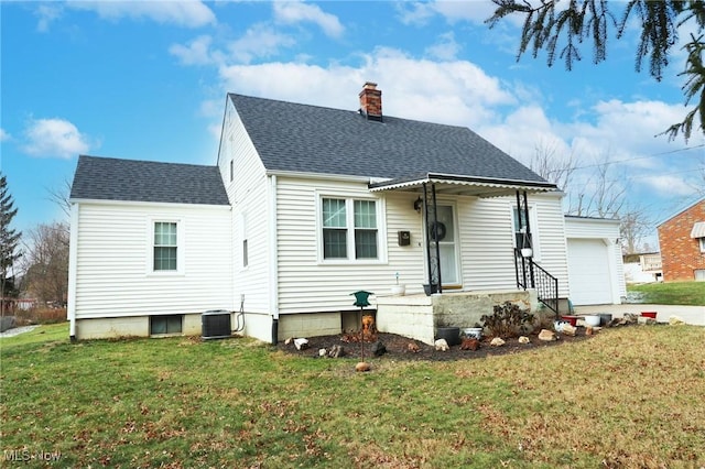 view of front of property with central air condition unit, a front lawn, and a garage