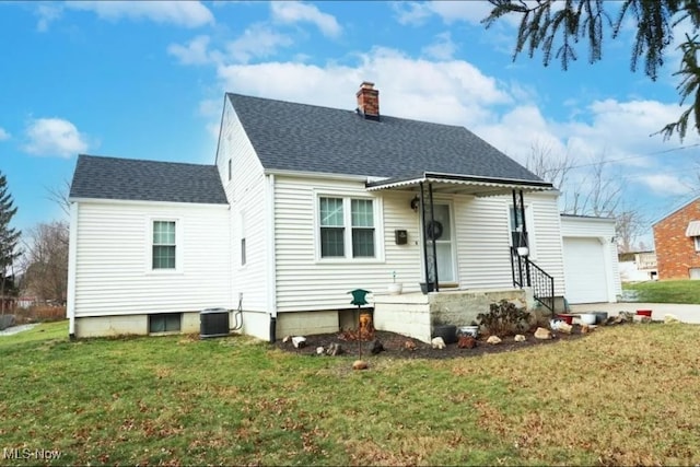 rear view of property featuring central AC, a yard, and a garage