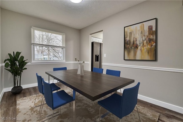 dining room with dark hardwood / wood-style floors and a textured ceiling