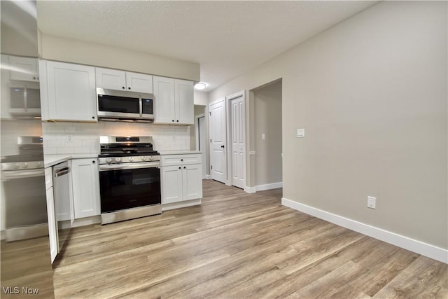 kitchen featuring white cabinets, appliances with stainless steel finishes, tasteful backsplash, and light hardwood / wood-style floors