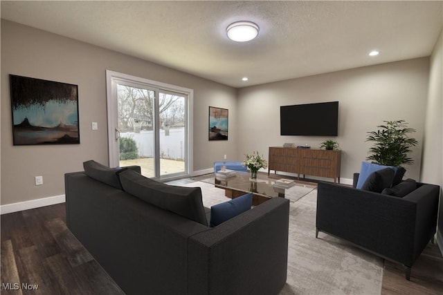 living room with wood-type flooring and a textured ceiling