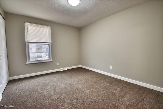 carpeted spare room featuring a textured ceiling