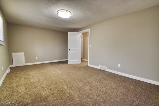 carpeted empty room with a textured ceiling