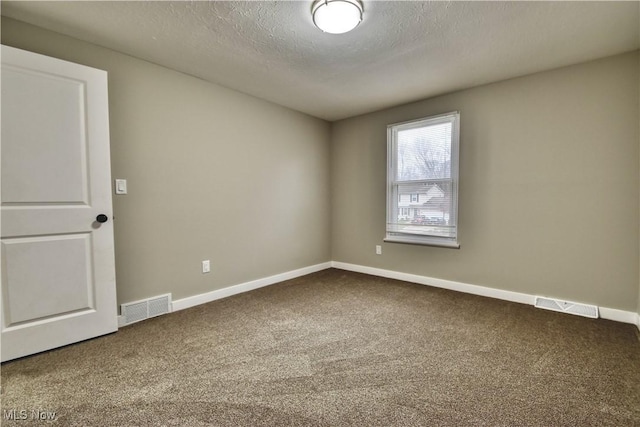 carpeted empty room with a textured ceiling