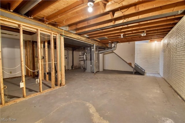 basement with heating unit and brick wall