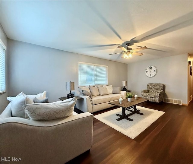 living room featuring dark wood-type flooring and ceiling fan