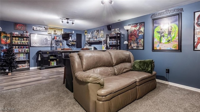 home theater with track lighting, wood-type flooring, and indoor bar