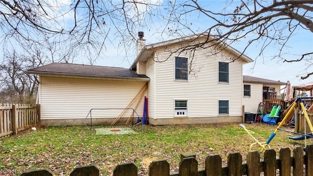 back of house featuring a playground, central AC, and a lawn