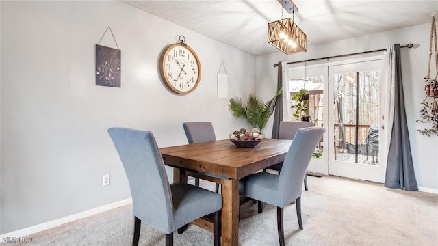 carpeted dining space featuring a notable chandelier