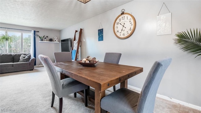 dining space with carpet flooring and a textured ceiling