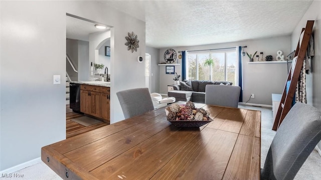 dining area with hardwood / wood-style flooring, sink, and a textured ceiling