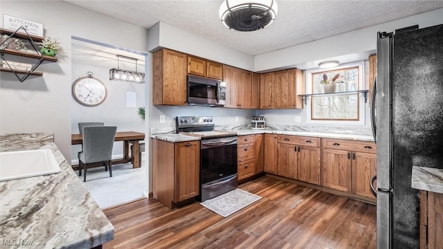 kitchen with appliances with stainless steel finishes, a textured ceiling, dark wood-type flooring, and sink