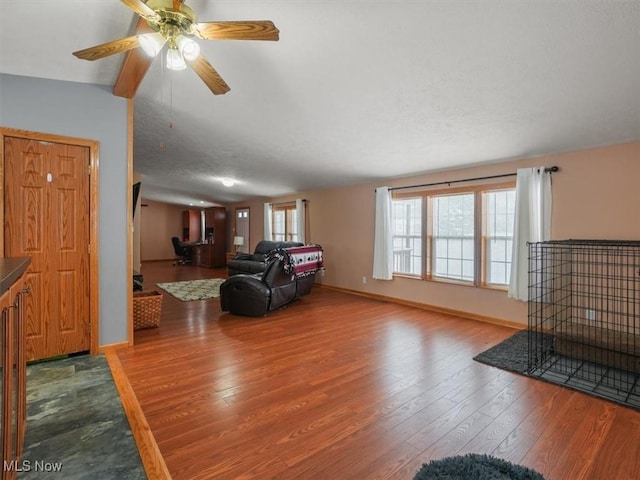 living room featuring hardwood / wood-style floors, vaulted ceiling, and ceiling fan