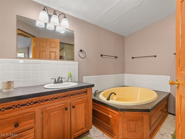 bathroom with backsplash, a tub, vanity, and a textured ceiling