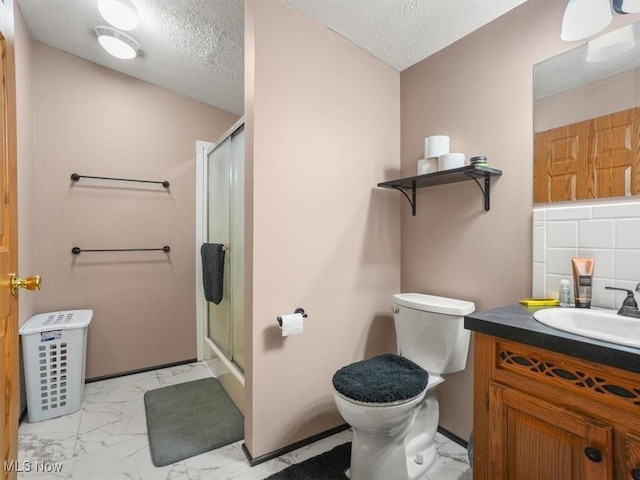 bathroom with a textured ceiling, an enclosed shower, and backsplash