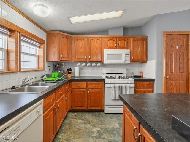 kitchen with backsplash, sink, vaulted ceiling, and white appliances