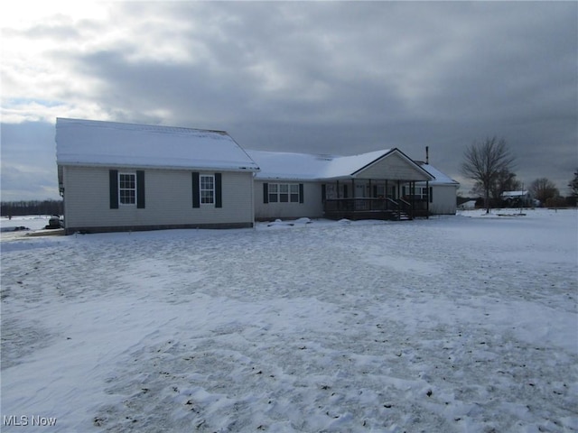 view of snow covered rear of property