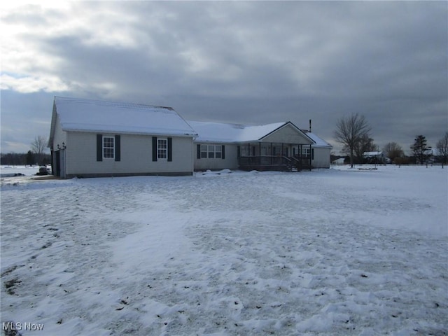 view of snow covered rear of property