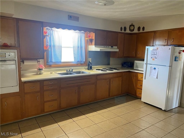 kitchen featuring light tile patterned floors, white appliances, washer / clothes dryer, and sink