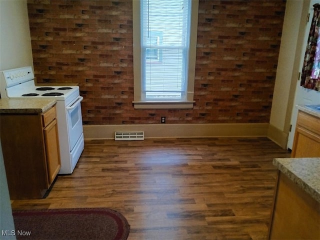 kitchen featuring white electric range oven and dark hardwood / wood-style flooring