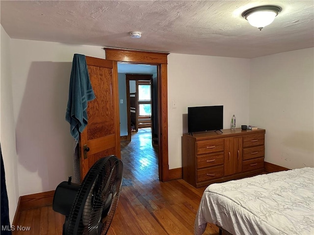 bedroom with wood-type flooring and a textured ceiling