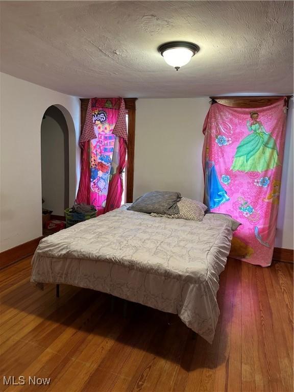 bedroom featuring wood-type flooring and a textured ceiling