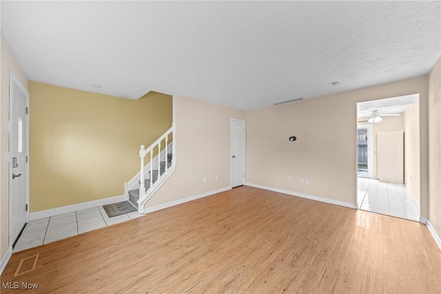 unfurnished living room with light wood-type flooring and ceiling fan