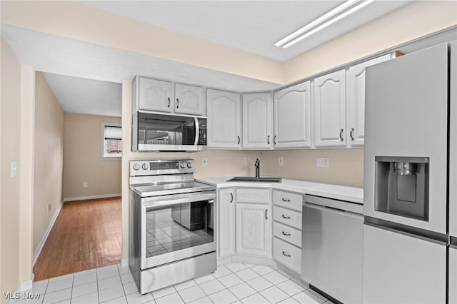 kitchen with white cabinetry, light hardwood / wood-style floors, and appliances with stainless steel finishes