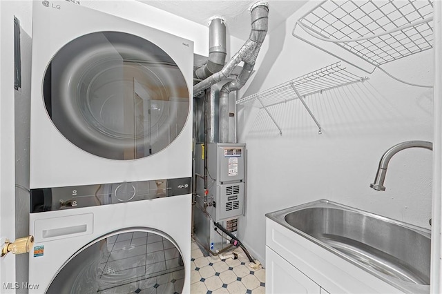 laundry area with stacked washing maching and dryer and sink