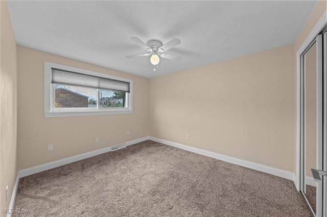 carpeted spare room with ceiling fan