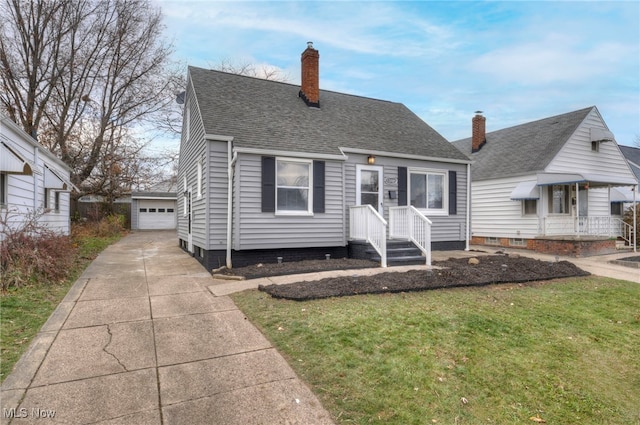 view of front of property featuring a front yard, an outdoor structure, and a garage