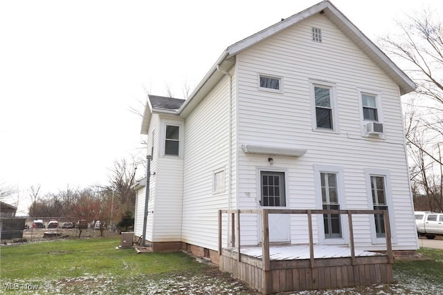 rear view of house featuring a lawn and cooling unit