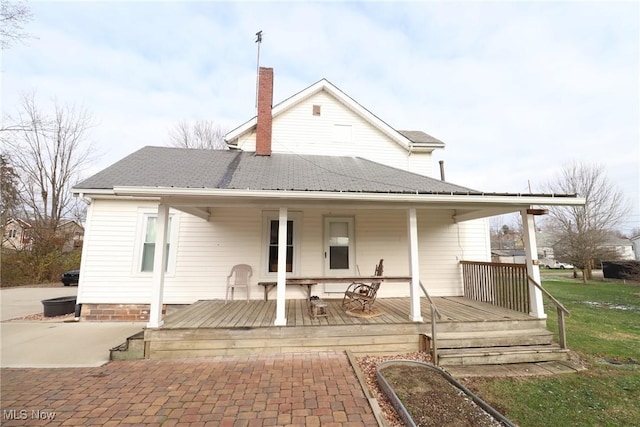 back of property featuring covered porch