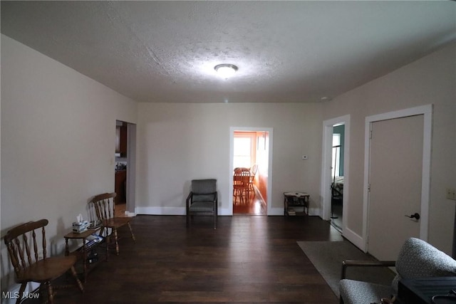 sitting room featuring a textured ceiling and dark hardwood / wood-style floors