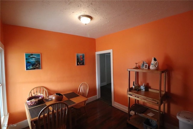 dining area with dark hardwood / wood-style flooring and a textured ceiling