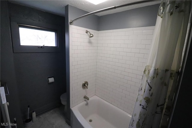 bathroom featuring toilet, shower / bath combo with shower curtain, and a textured ceiling